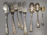 cinq cuillères en argent et six cuillères en argent sur une table