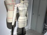 two mannequins sitting on a stand in a room