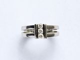 gros plan d'une bague en argent sur une surface blanche