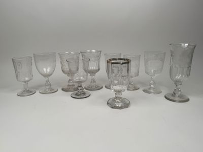 Plusieurs verres à pied et tasses sont alignés sur une surface blanche