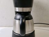 a black and silver coffee maker on a white counter