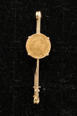 un gros plan d'une clé dorée sur laquelle repose une pièce de monnaie