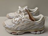 La chaussure est blanche et possède une semelle marron.