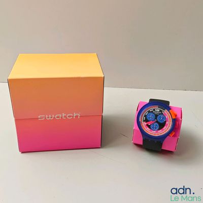 une montre Swatch dans une boîte rose, à côté d'une boîte rose et jaune
