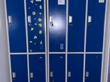 several blue lockers are lined up against a wall in a room