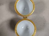 three white and gold dishes on a table