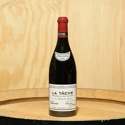 a bottle of wine sitting on top of a barrel