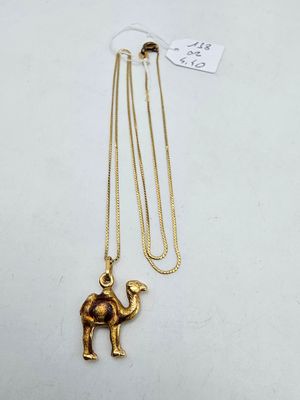 a gold necklace with a camel on it and a gold chain