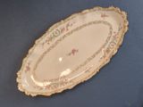 a white plate with pink flowers on it on a blue table