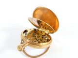 a gold clock inside of a gold ring on a white surface