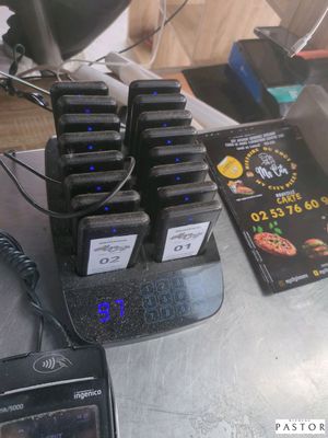 Plusieurs téléphones portables sont posés sur une table, à côté de nombreux chargeurs.