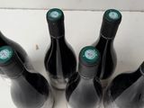 four bottles of wine are lined up on a table