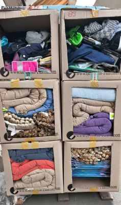 Plusieurs cartons de vêtements sont empilés les uns sur les autres