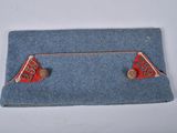 blue felt purse with red and gold studs on top of it
