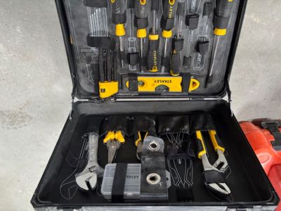 de nombreux outils dans une boîte à outils posée par terre
