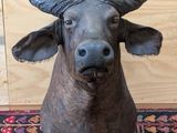 une statue de taureau posée sur un tapis, à même le sol