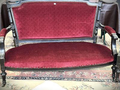 un canapé rouge posé sur un tapis dans un salon