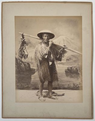 une vieille photo d'un homme coiffé d'un chapeau et tenant un bâton