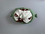 a green basket filled with apples sitting on top of a table