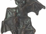 une statue représentant une chauve-souris, accrochée à un mur