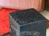 a small black box sitting on a table next to a red box