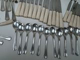 a lot of spoons and spoon knives on the table