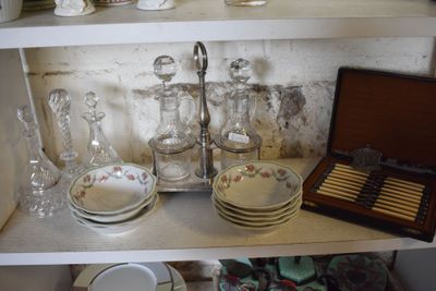 a shelf that has a lot of dishes and cups on it