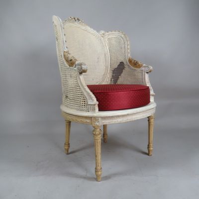 une chaise blanche sur laquelle est posé un coussin rouge