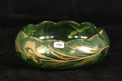a green bowl with gold designs on it on a black background