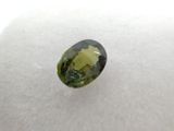 a close up of a green tourmaline stone on a white surface