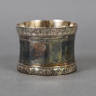 un rond de serviette ancien en métal argenté, orné d'un motif