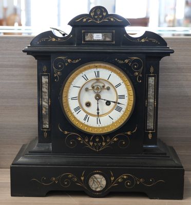 a black and gold clock sitting on a wooden table