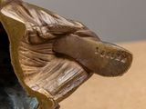 a bronze statue of a man sitting on a bench