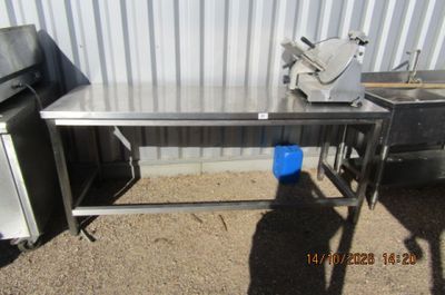 une table en acier inoxydable sur laquelle se trouve un seau bleu