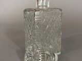 a clear glass bottle with a handle on a table