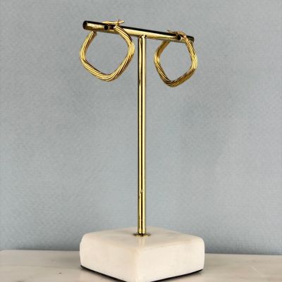 un gros plan sur une paire de boucles d'oreilles posées sur un présentoir sur une table