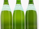 trois bouteilles de vin posées les unes à côté des autres sur une surface blanche