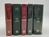 four books are lined up in a row on a white surface