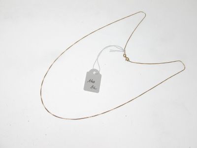 un collier auquel est attachée une étiquette sur une surface blanche