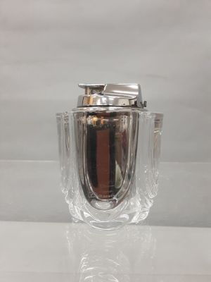 a glass vase with a silver lid sitting on a table