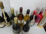 many bottles of wine sitting on a table next to each other