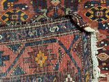 a close up of a red and blue rug on a wooden floor