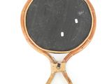 a small mirror with a wooden handle hanging on a wall