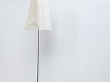 lampe sur pied en forme d'abat-jour, avec un pied en métal noir et un abat-jour en tissu blanc