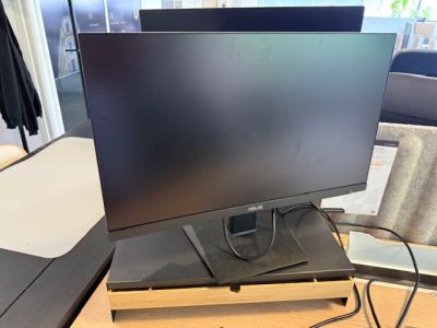 un écran d'ordinateur posé sur un bureau en bois