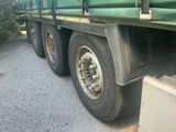 a green truck that is parked on the side of the road