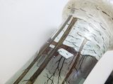 a glass vase with a painting on it sitting on a table