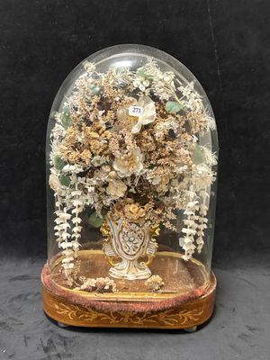 un dôme en verre renfermant un vase de fleurs