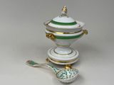 un bol vert et blanc et une cuillère posés sur une table