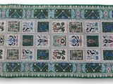 un tapis vert et bleu orné de fleurs et de feuilles